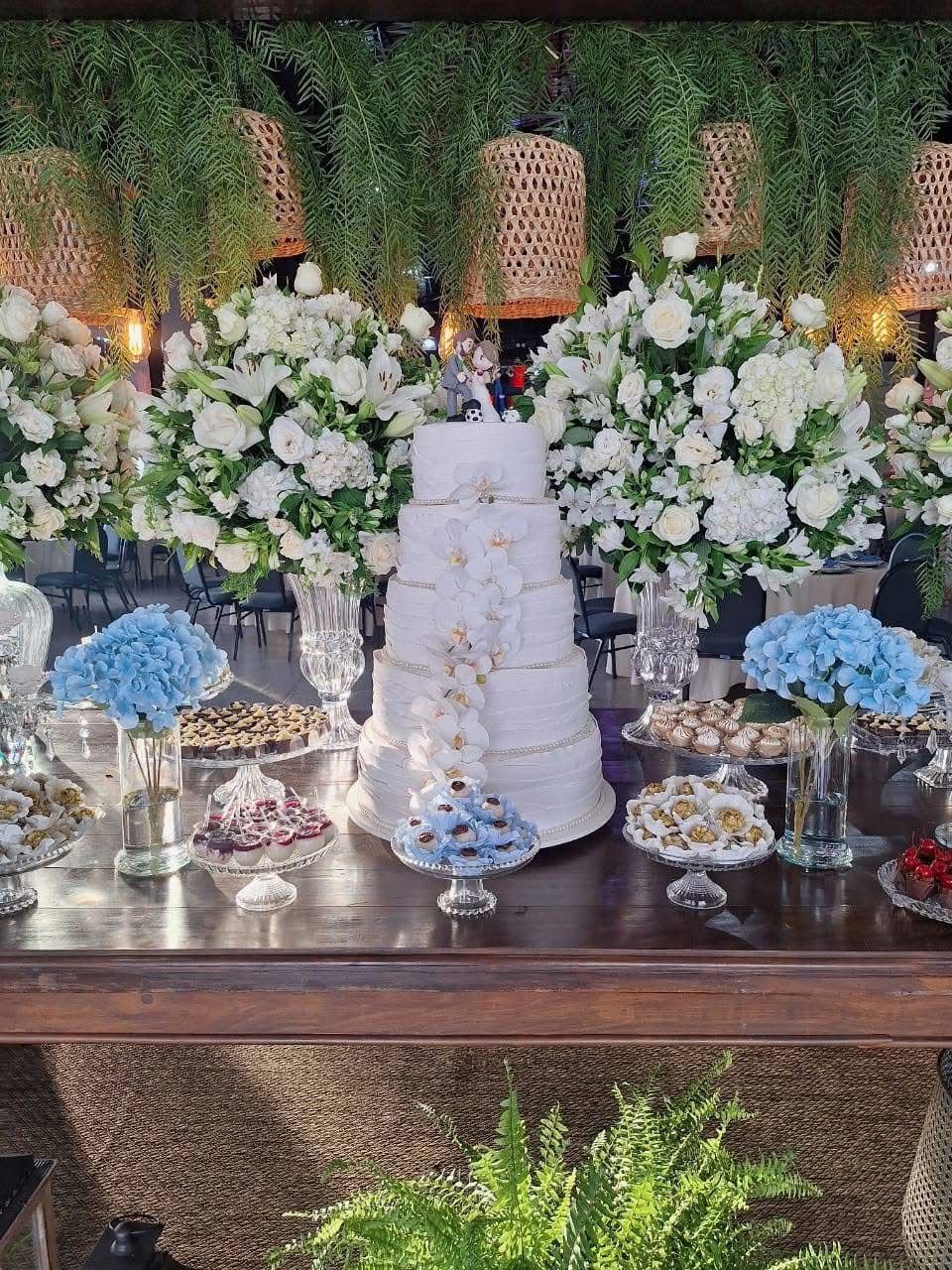 Mesa de casamento decorada com flores brancas, cristais e folhagens